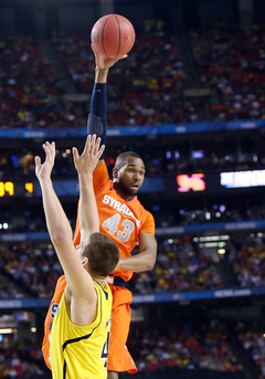 James Southerland #43of the Syracuse Orange passes the ball against Mitch McGary #4.