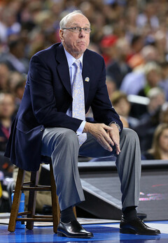 Jim Boeheim sits on a stool next to the court during the first half.