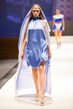 Modeling a blue dress designed by Lailee Waxman, Natalia Foresy walks  the runway.