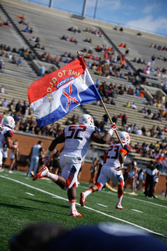 Eric Crume raises a Fort Drum flag as he races onto the field prior to SU's game against the Demon Deacons. 