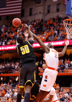 SU forward Tyler Roberson reaches for a loose ball against Kouassi.