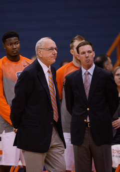 SU head coach Jim Boeheim, standing next to assistant coach Gerry McNamara, looks on.