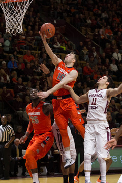 Trevor Cooney rises for a finger roll with Hokies guard Devin Wilson on his back.