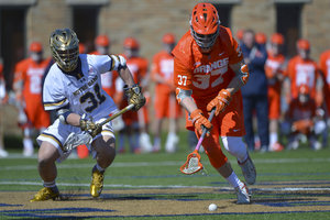 Syracuse faceoff specialist Ben Williams pursues a loose ball against Notre Dame's P.J. Finley during SU's 13-12 loss to the Fighting Irish.