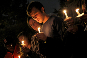 Jesse Nichols, a senior public relations, international relations and citizenship and civic engagement major, attends a candlelight vigil outside Hendricks Chapel on Tuesday night to honor the victims and families of the Umpqua Community College shooting. The shooting, which killed nine people, took place in Roseburg, Oregon. About 40 members of the SU community attended the Tuesday vigil.