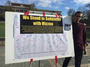 A SUNY-ESF student stands with a large petition on the ESF quad to show solidarity with protesters at the University of Missouri.
