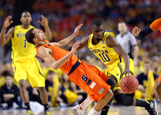 Tim Hardaway Jr. #10 of the Michigan Wolverines drives to the basket against Michael Carter-Williams #1 of the Syracuse Orange.