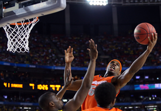 C.J. Fair #5 of the Syracuse Orange puts the ball up to the basket against the Michigan Wolverines.