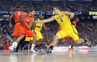 Michael Carter-Williams #1 of the Syracuse Orange holds the ball against Mitch McGary #4 of the Michigan Wolverines.