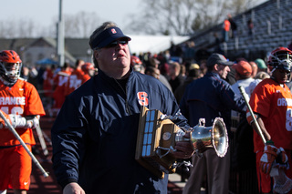 Director of Operations Roy Simmons III carries the Kraus-Simmons Trophy after Syracuse's victory.
