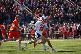 Teddy Sisco holds his stick away from a Syracuse midfielder.