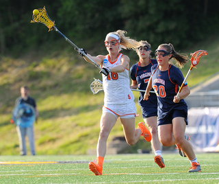 Orange midfielder Katie Webster flips a pass ahead with a pair of UVA attacks trailing.