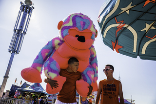 Cameryn Williams (left) carries a giant stuffed ape on his back, a prize his friend Nate Johns (right) won in a game at the fair. Like Williams, guests can win prizes at one of the many carnival game booths found throughout the fairgrounds.