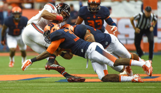 A pair of Syracuse defenders converge to bring down a Louisville ball carrier.