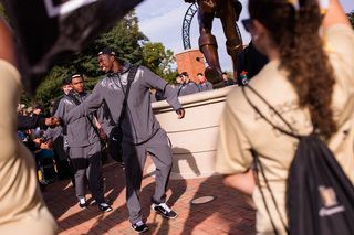 A Wake Forest player shakes hands with a fan in the crowd prior to the start of the Demon Deacons' game against Syracuse.
