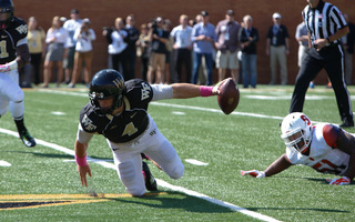 Backup quarterback Tyler Cameron stumbles as he tries to hold on to the ball. 