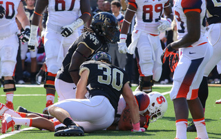 Hunter Williams tackles an SU player while Josh Parris watches just feet away. 
