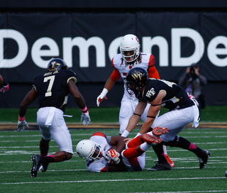 A Syracuse player curls up as he prepares to get tackled by Merrill Noel.