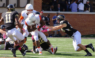 A Syracuse running back is tackled by the Wake Forest defense. SU finished with 199 yards on the ground.