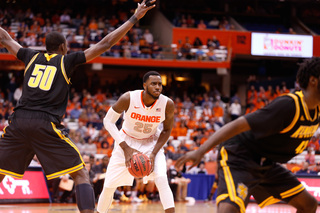 Christmas handles the ball as Kouassi raises both hands to defend against the SU center.