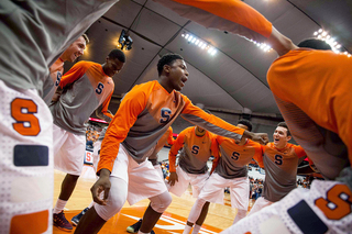 Doyin Akintobi-Adeyeye dances in the middle of the Syracuse huddle before the start of the game.