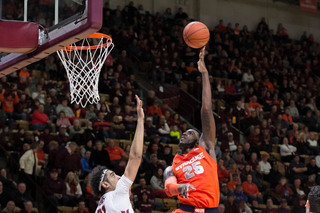 Rakeem Christmas lofts a left-handed hook shot over VT's Satchel Pierce. The SU senior had 10 points in the opening 20 minutes.