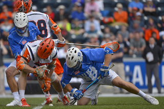 Syracuse's Ben Williams fights with Duke's Kyle Rowe for a faceoff near midfield.